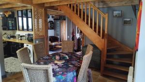 ein Esszimmer mit einem Tisch und einer Treppe in der Unterkunft Gite Esprit du Monde in Kervignac