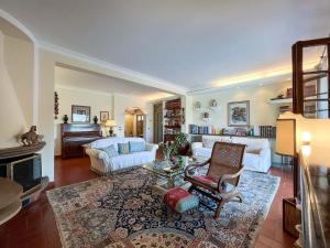 a living room with white furniture and a piano at Casa Le Agavi in Portoferraio