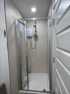 una ducha con puerta de cristal en un baño en Ballycastle, Beachside Apartment, en Ballycastle 24 fotos más