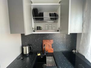 a kitchen with a black counter top and white cabinets at Vironia Apart in Kohtla-Järve