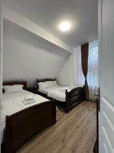 Cette chambre comprend 2 lits et une fenêtre. dans l'établissement Casa valea gilortului, à Rânca
