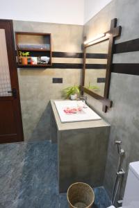 a bathroom with a sink and a mirror at Monkey Island Hotel in Hikkaduwa