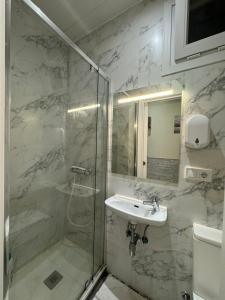 y baño con ducha acristalada y lavamanos. en HABITACION CENTRAL CON WIFI, en Bilbao