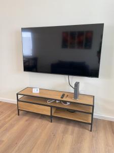 a large flat screen tv on a wall with a coffee table at Spatzennest Monteurzimmer in Korbach