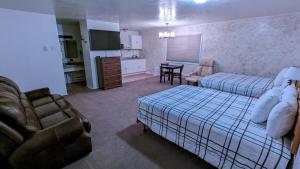 a bedroom with a bed and a couch and a kitchen at High Desert Inn in Salina