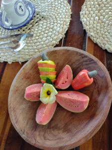 un plato de frutas y hortalizas en una mesa de madera en Odoyá Corumbau, en Corumbau