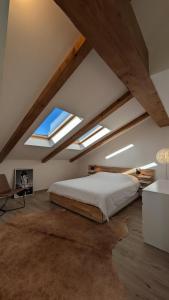 a bedroom with a large bed and some skylights at Charming Barolo Wine Loft in Monforte dʼAlba