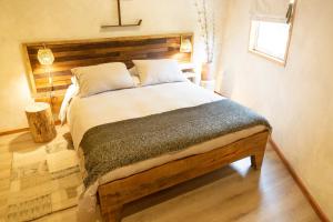 1 dormitorio con 1 cama grande y cabecero de madera en Ascenso Kimun, en Pucón