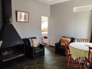 sala de estar con chimenea, mesa y sillas en Casa Vacacional MIA, en Piriápolis