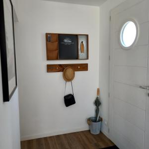 a hallway with a white wall with a window and a door at La désirée à Noirmoutier in Noirmoutier-en-l'lle +5 photos