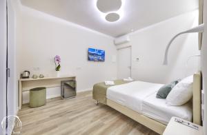 a white bedroom with a bed and a desk at FORESTERIA GUESTHOUSE CA' DEI BACHITT in Lierna