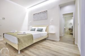 a white bedroom with a large bed and a desk at FORESTERIA GUESTHOUSE CA' DEI BACHITT in Lierna