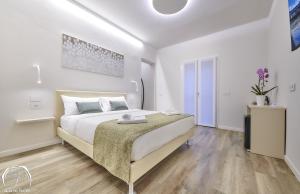 a white bedroom with a large bed in a room at FORESTERIA GUESTHOUSE CA' DEI BACHITT in Lierna