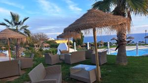 a group of chairs and umbrellas next to a pool at Casa da Rocha in Armação de Pêra