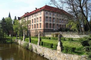 a large brick building next to a river at Chalupa Ohře in Libochovice