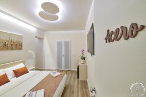 a white bedroom with a bed and a door at FORESTERIA GUESTHOUSE CA' DEI BACHITT in Lierna