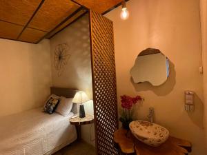 ein Schlafzimmer mit einem Bett und einem Tisch mit einer Lampe in der Unterkunft Orquídea Loft in Juayúa