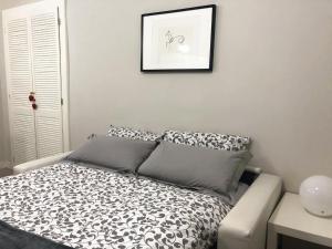1 dormitorio con 1 cama con sábanas blancas y negras en "le Volte" Appartamento nel cuore di Foligno en Foligno