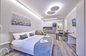 a bedroom with a large white bed and a kitchen at FORESTERIA GUESTHOUSE CA' DEI BACHITT in Lierna