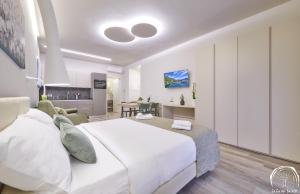 a bedroom with a large white bed and a living room at FORESTERIA GUESTHOUSE CA' DEI BACHITT in Lierna