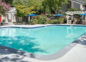 a large blue swimming pool in front of a house at Entire 2 Bedroom Apt Home in Sandy Springs in Sandy Springs
