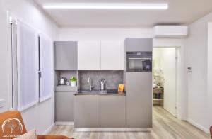 a kitchen with white cabinets and a sink at FORESTERIA GUESTHOUSE CA' DEI BACHITT in Lierna