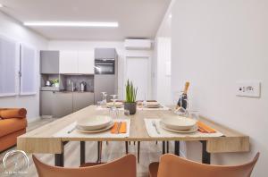 a kitchen with a large wooden table with chairs at FORESTERIA GUESTHOUSE CA' DEI BACHITT in Lierna
