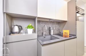 a kitchen with white cabinets and a sink at FORESTERIA GUESTHOUSE CA' DEI BACHITT in Lierna