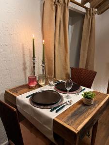 a wooden table with plates and wine glasses on it at Gîte La Petite Francorchamps Ardennaise in Stavelot
