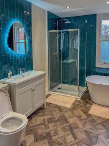 a bathroom with a toilet and a tub and a sink at The Castle City Centre Apartment in Canterbury