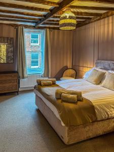 a bedroom with a large bed and a chandelier at The Castle City Centre Apartment in Canterbury