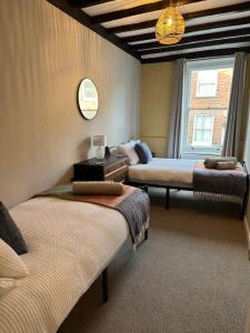 a room with two beds and a window at The Castle City Centre Apartment in Canterbury