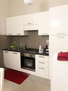 cocina blanca con fogones y armarios blancos en "le Volte" Appartamento nel cuore di Foligno en Foligno