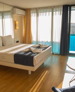 a large bed in a room with windows at Luxury PANORAMA sea view apartment & Central Batumi in Batumi