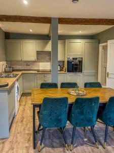 a kitchen with a wooden table and blue chairs at The Castle City Centre Apartment in Canterbury