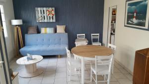 un salon avec un canapé bleu et une table dans l'établissement Duplex avec 3 chambres à 30m de la plage, à Merlimont