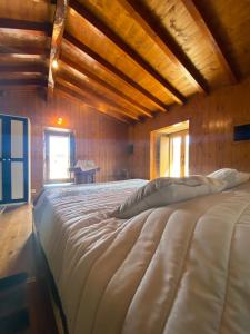 1 cama blanca grande en una habitación de madera en Casa do Lagar, 