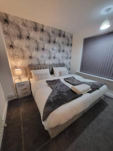 a bedroom with a large bed with a wall at 3 Bed Home - Sleeps up to 5 - Coventry - Contractors, Families and Relocators in Coventry