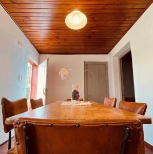 un tavolo da pranzo con sedie e un soffitto in legno di El Cencerro - Casa de Campo a Villa Lía
