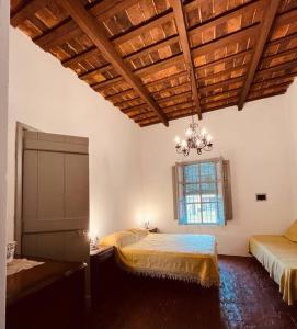 una camera con letto, lampadario a braccio e finestra di El Cencerro - Casa de Campo a Villa Lía