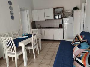 a kitchen with a table and chairs and a couch at Moby Dick House in Villasimius