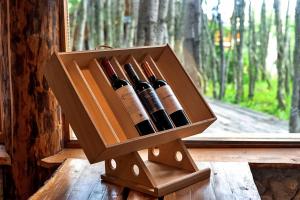 Patagonia Villa Lodge في أوشوايا: صندوق خشبي من زجاجات النبيذ على حافة النافذة
