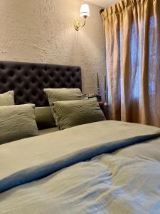 a bedroom with a bed with a headboard and a window at Gîte La Petite Francorchamps Ardennaise in Stavelot