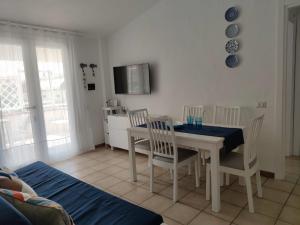 a dining room with a white table and chairs at Moby Dick House in Villasimius