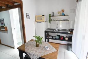 una pequeña cocina con mesa y nevera blanca en Chalé pertinho de Jurerê Ch1, com Fire Stick en Florianópolis