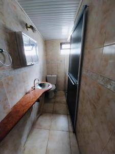 Un baño pequeño con lavabo e inodoro. en Villa Violetta, en Punta del Este