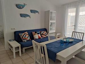 a living room with a blue couch and a table at Moby Dick House in Villasimius