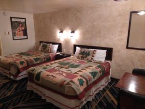 a hotel room with two beds and a table at High Desert Inn in Salina