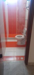een badkamer met een toilet en rode en witte muren bij La Casa de Yeny in Borrero Ayerbe