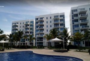 2 grandes edificios de apartamentos con piscina en la parte delantera en Playa Blanca Coral Park, en Río Hato